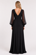 A woman viewed from the back wearing a floor-length black gown with sheer long balloon sleeves and a deep V back, photographed against a plain light studio background.