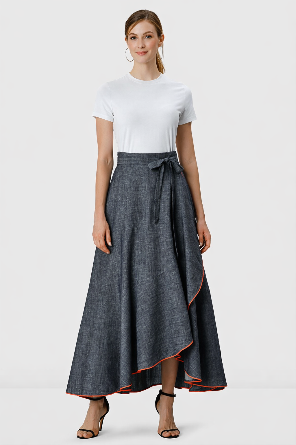 Woman wearing a cotton chambray faux wrap skirt with contrast trim and tie waist