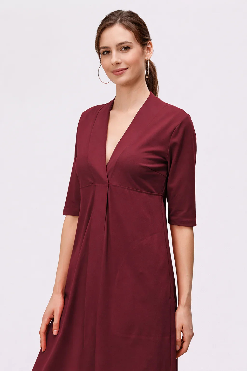 Cotton jersey empire A-line dress with deep V-neck, casual midi length, worn by a model in a work and everyday setting.
