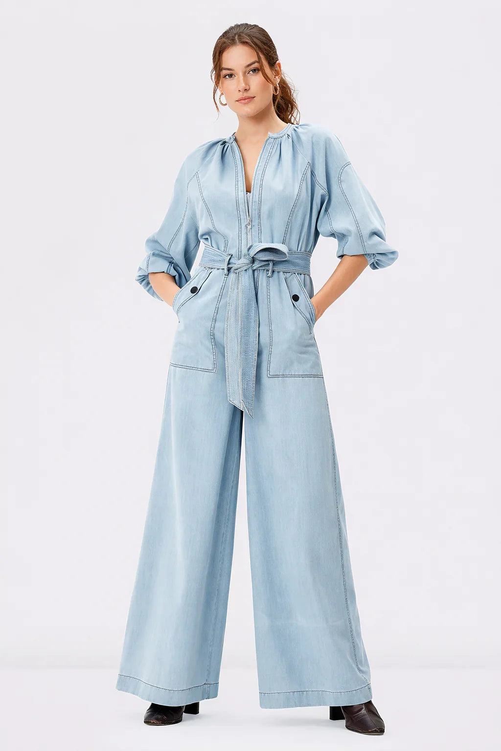 Light wash cotton denim palazzo jumpsuit with zip-front closure, wide-leg design, and belted waist by Nams-Ropa.