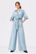 Light wash cotton denim palazzo jumpsuit with zip-front closure, wide-leg design, and belted waist by Nams-Ropa.