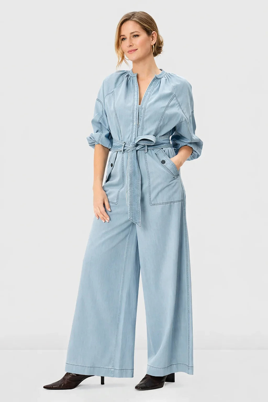 Light wash cotton denim palazzo jumpsuit with zip-front, wide-leg design, belted waist, by Nams-Ropa.