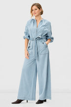 Light wash cotton denim palazzo jumpsuit with zip-front, wide-leg design, belted waist, by Nams-Ropa.