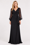 A woman modeling a floor-length black gown with a deep V-neckline, sheer long balloon sleeves, and a gathered waist detail, photographed against a plain light gray studio background.
