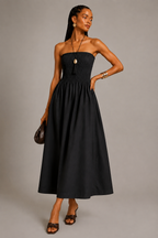 Black strapless cotton maxi dress with smocked bodice and flowy gathered skirt worn by a fashion model.
