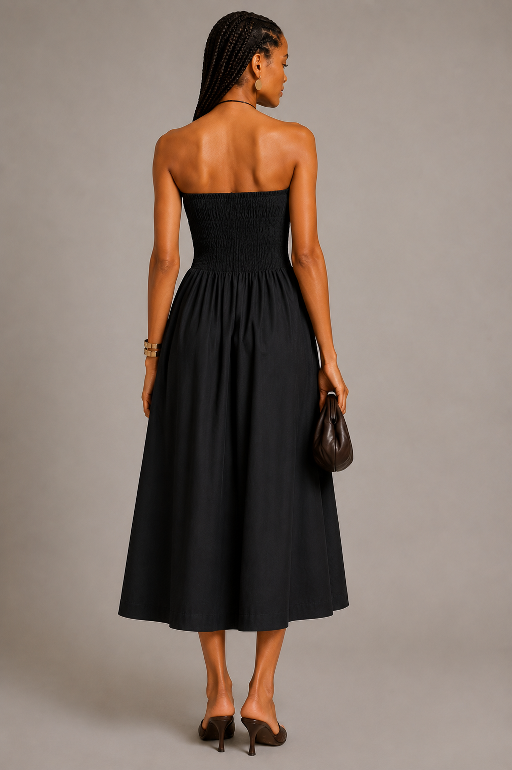 Black strapless cotton maxi dress with smocked bodice and flowy gathered skirt worn by a fashion model.
