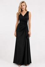 A woman modeling a sleeveless black maxi dress with a V-neckline and draped wrap-style bodice, standing against a plain light gray studio background.