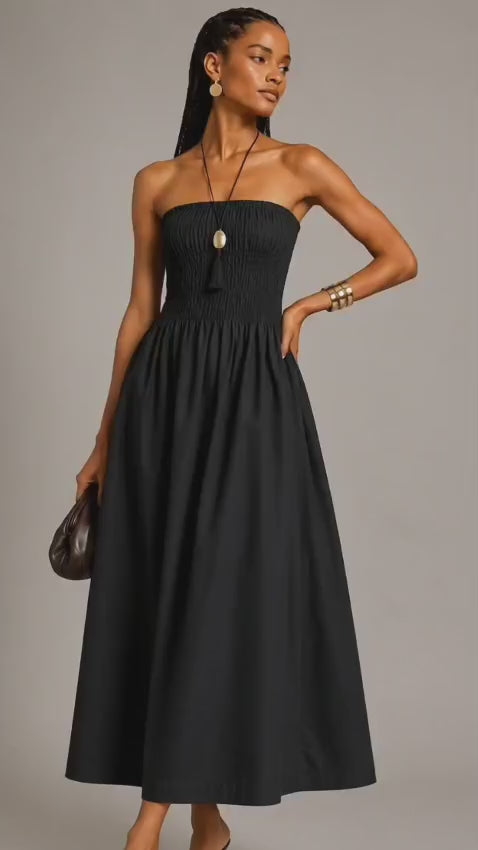 Black strapless cotton maxi dress with smocked bodice and flowy gathered skirt worn by a fashion model.
